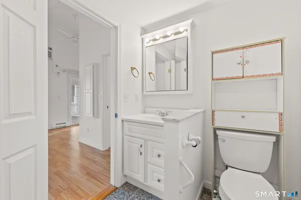 a bathroom with a toilet a sink and a mirror