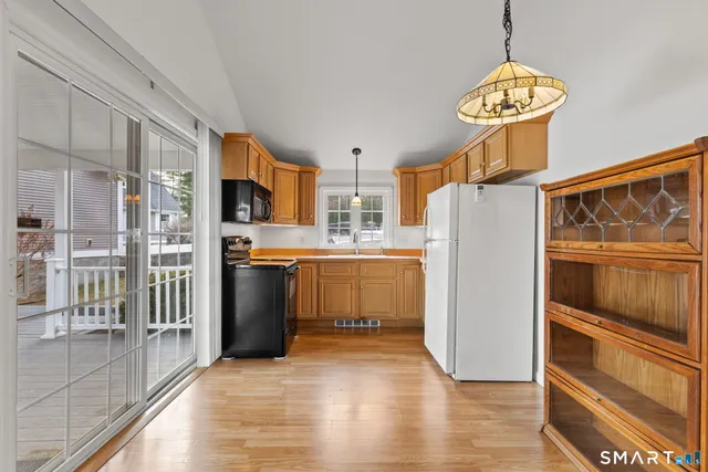 a kitchen with stainless steel appliances granite countertop a refrigerator a oven and a stove with wooden floors