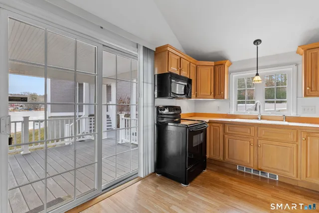 a kitchen with stainless steel appliances granite countertop a refrigerator a sink and white cabinets