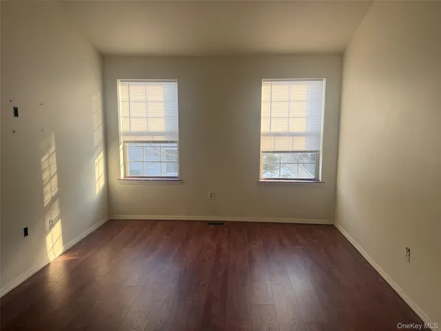 an empty room with wooden floor & closet