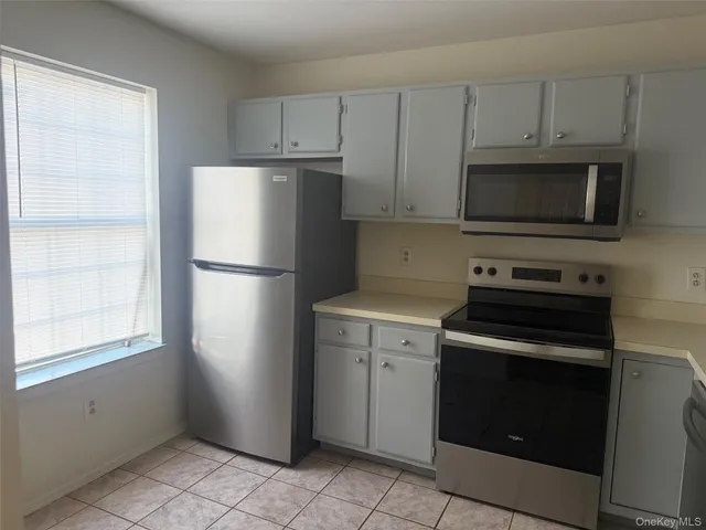 a kitchen with cabinets stainless steel appliances and a window