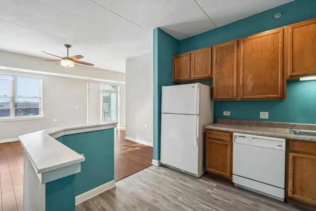 a kitchen with a refrigerator sink and cabinets