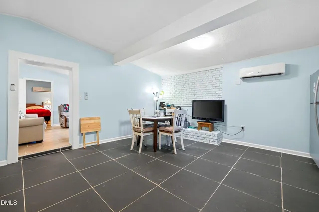 a living room with furniture a flat screen tv and a dining table