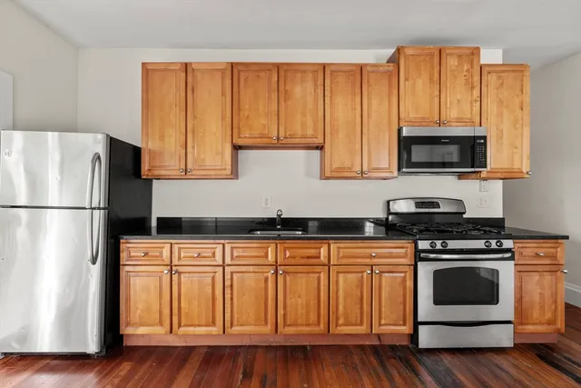 a kitchen with stainless steel appliances granite countertop a stove a sink and a microwave