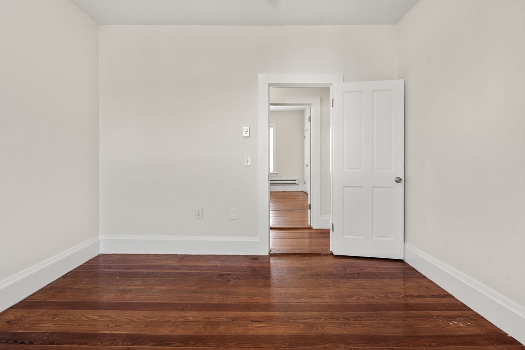 27 Buttonwood Street Boston, MA 02125 - Photo 6 of 12 a view of empty room with wooden floor