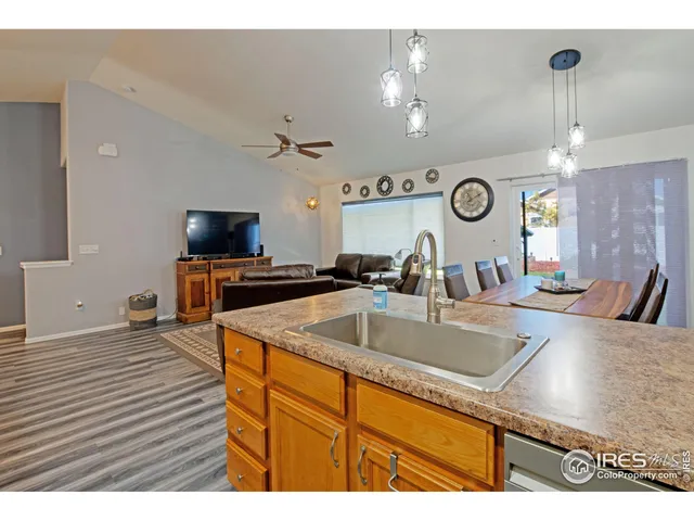 a kitchen with a sink and a stove with wooden floor