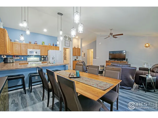 a dining hall with stainless steel appliances kitchen island granite countertop a dining table chairs and view kitchen