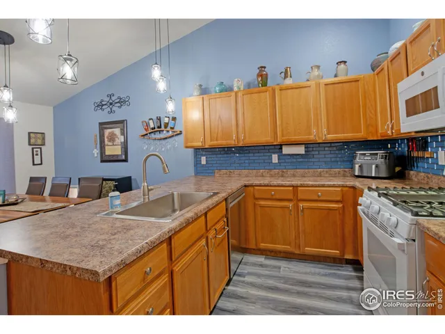 a kitchen with kitchen island granite countertop a sink cabinets and wooden floor