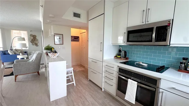 a kitchen with stainless steel appliances a stove microwave and sink