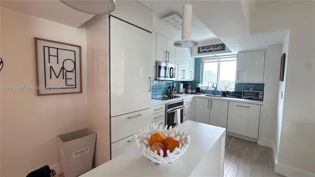 a kitchen with stainless steel appliances granite countertop a sink a stove and a refrigerator