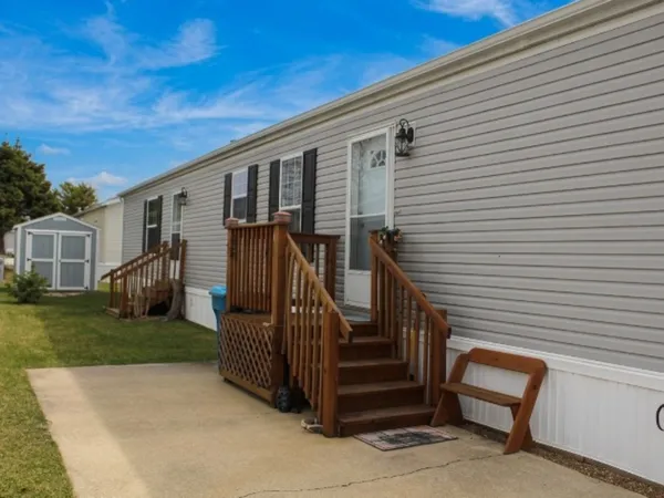 a view of a house with backyard and wooden fence