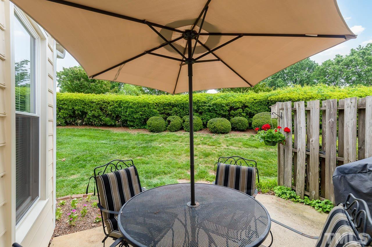 2715 Cottage Circle Raleigh, NC 27613 - Photo 23 of 26 a view of a patio with table and chairs potted plants and a small yard