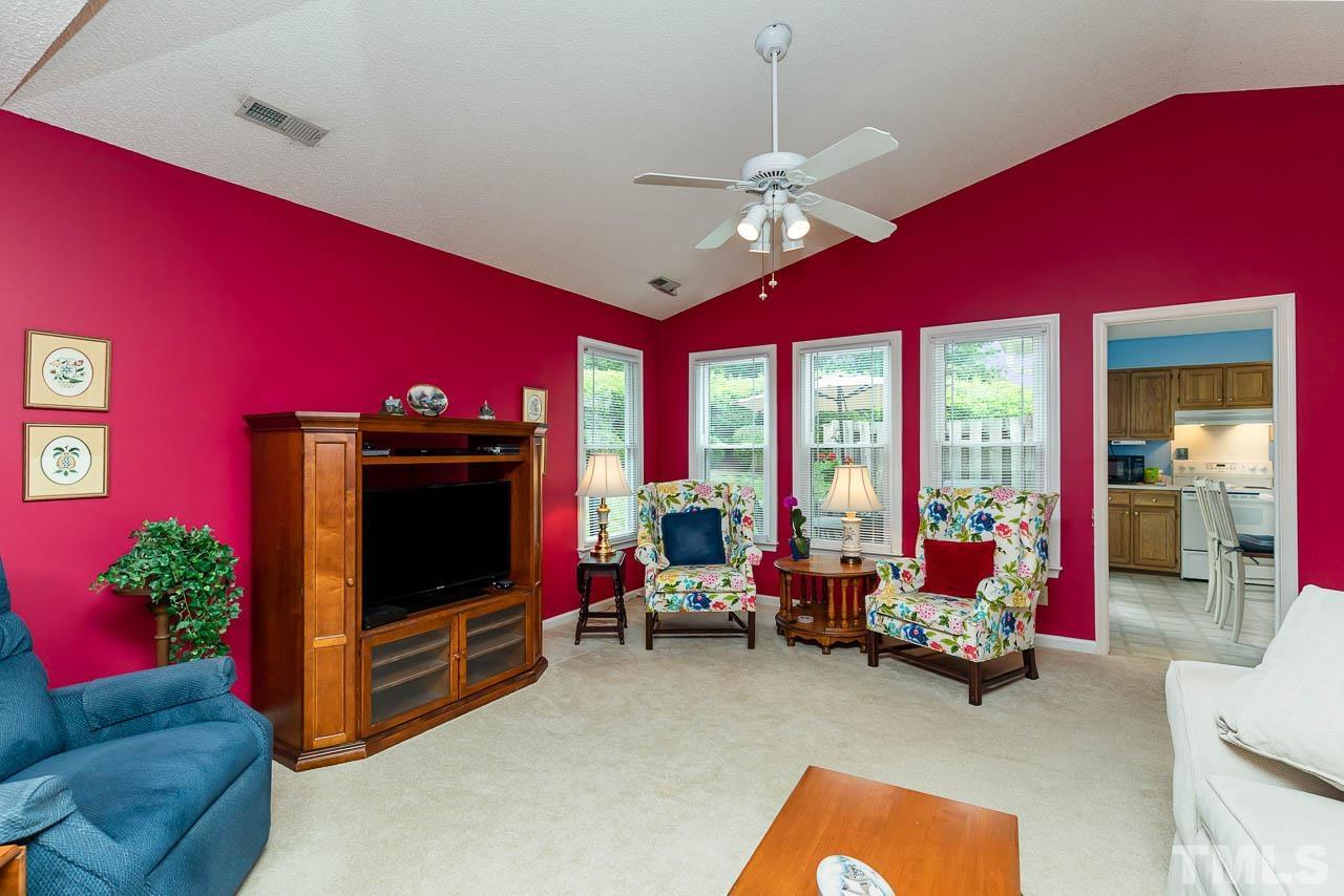 2715 Cottage Circle Raleigh, NC 27613 - Photo 9 of 26 a living room with furniture a flat screen tv and a floor to ceiling window