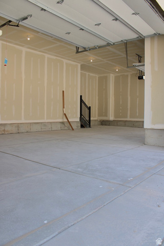 2613 Scarlet Road, Unit 258 Eagle Mountain, UT 84005 - Photo 32 of 32 Spacious garage featuring a concrete floor, exposed drywall walls, and overhead lighting