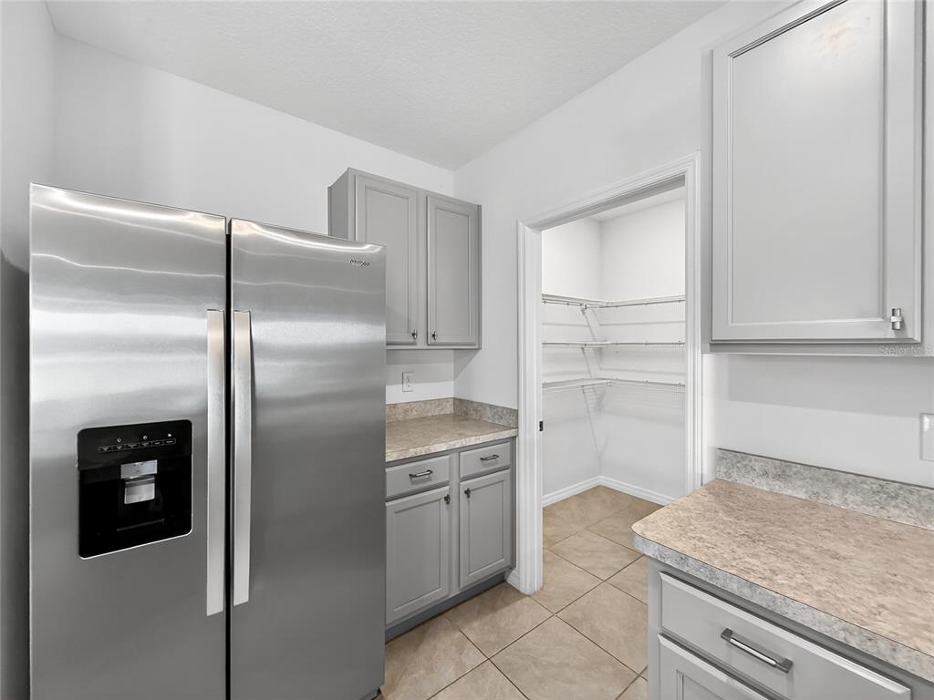 2597 Shamrock Street Tavares, FL 32778 - Photo 13 of 57 a kitchen with a refrigerator sink and cabinets