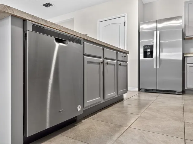 a kitchen with white cabinets and appliances