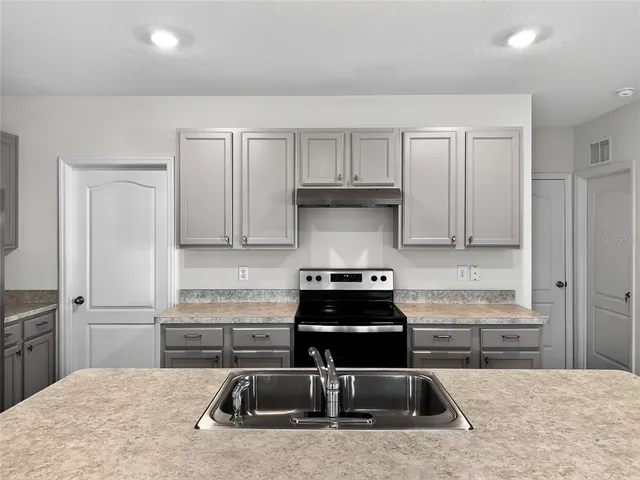 a kitchen with granite countertop a stove and a refrigerator