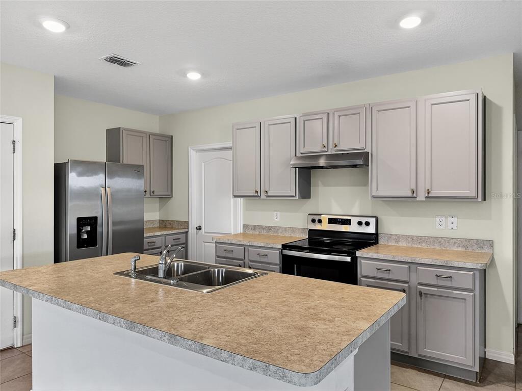 2597 Shamrock Street Tavares, FL 32778 - Photo 17 of 57 a kitchen with granite countertop a sink stove and refrigerator
