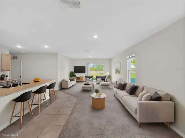 a living room with furniture kitchen and a table