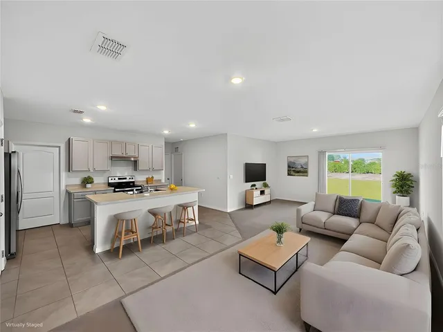 a view of kitchen with stainless steel appliances a stove top oven a sink and a refrigerator
