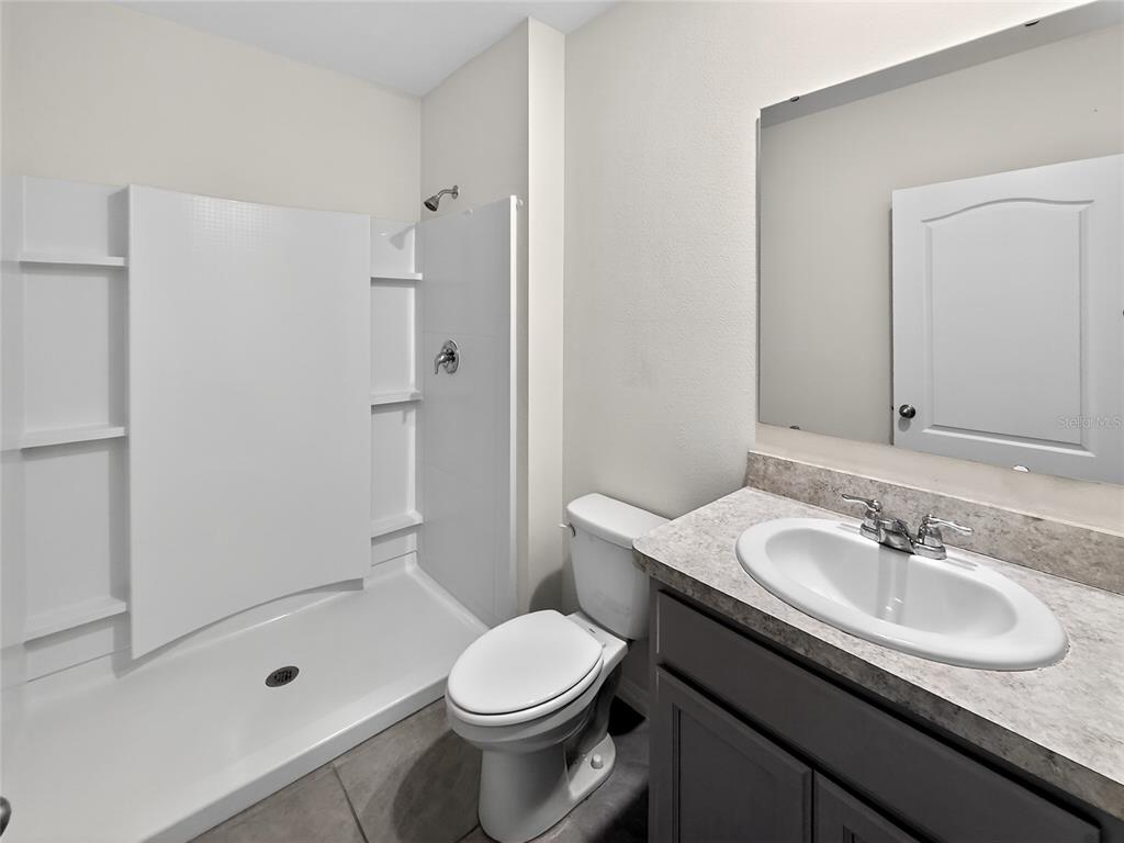 2597 Shamrock Street Tavares, FL 32778 - Photo 31 of 57 a bathroom with a sink a toilet and shower