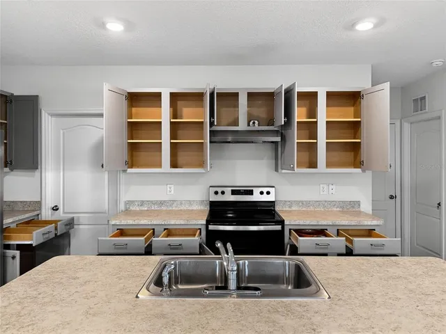 a kitchen that has a sink and a stove in it