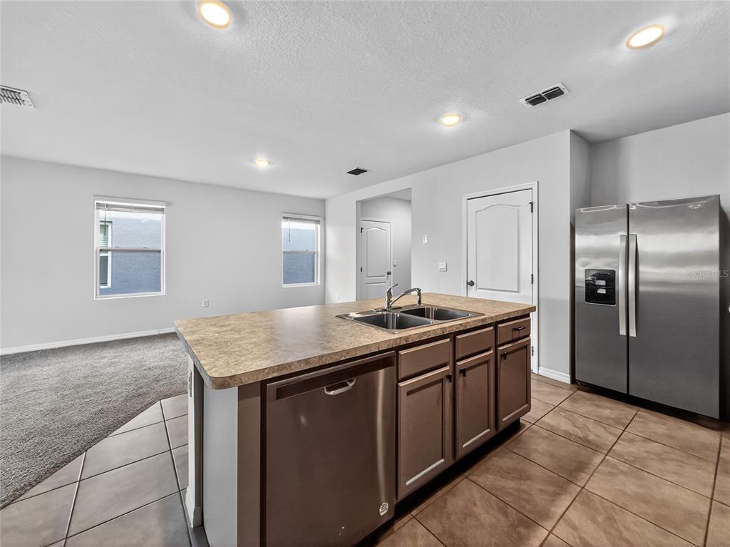 2597 Shamrock Street Tavares, FL 32778 - Photo 9 of 57 a kitchen with stainless steel appliances granite countertop a sink and a refrigerator