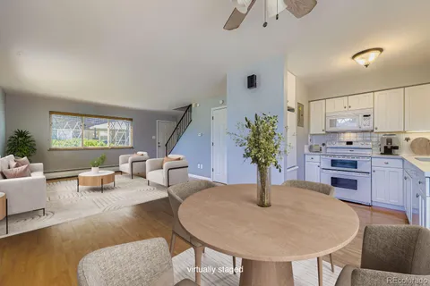 a kitchen with stainless steel appliances dining table a couch and a refrigerator
