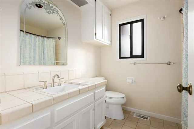 a spacious bathroom with a granite countertop sink and a mirror