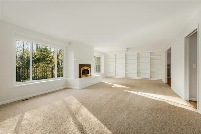 a living room with furniture fireplace and a large window