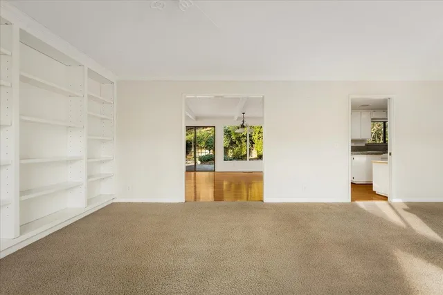 a large white kitchen with stainless steel appliances granite countertop a stove a sink and white cabinets with wooden floor