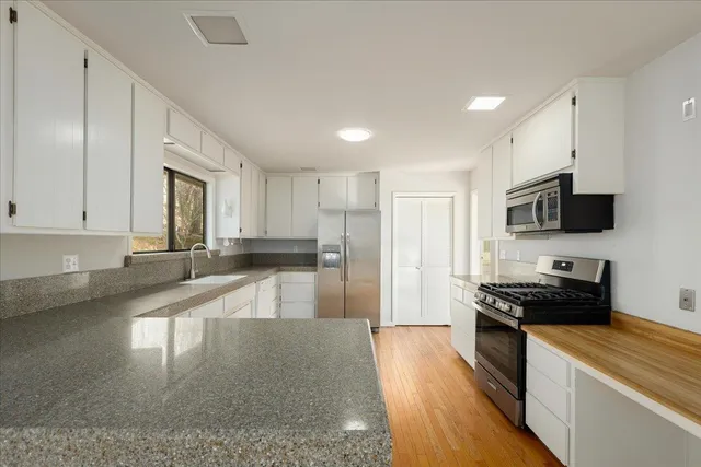 a kitchen with granite countertop white cabinets and a window