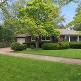 a front view of a house with a yard and trees