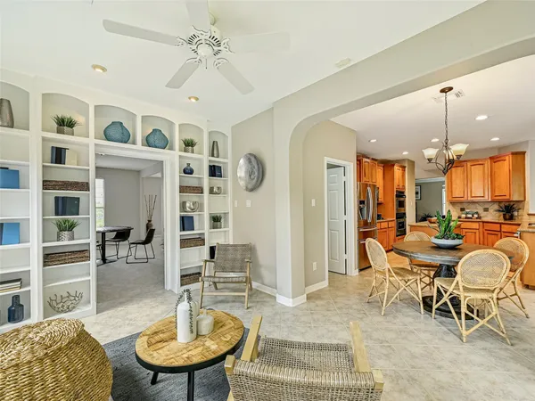 a living room with furniture a table and kitchen view