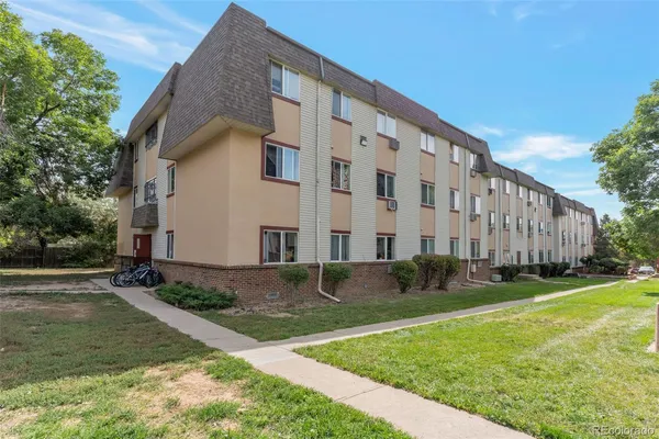 a view of a building with backyard and trees