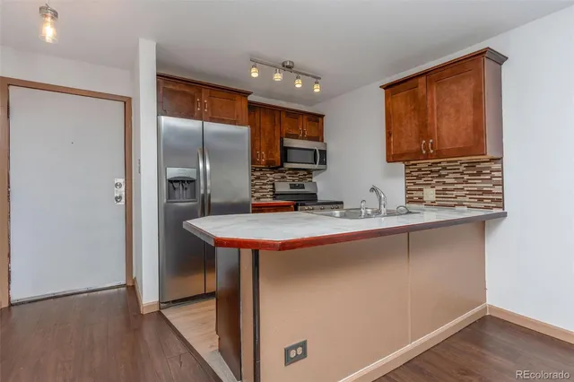 a kitchen with stainless steel appliances a sink and a refrigerator