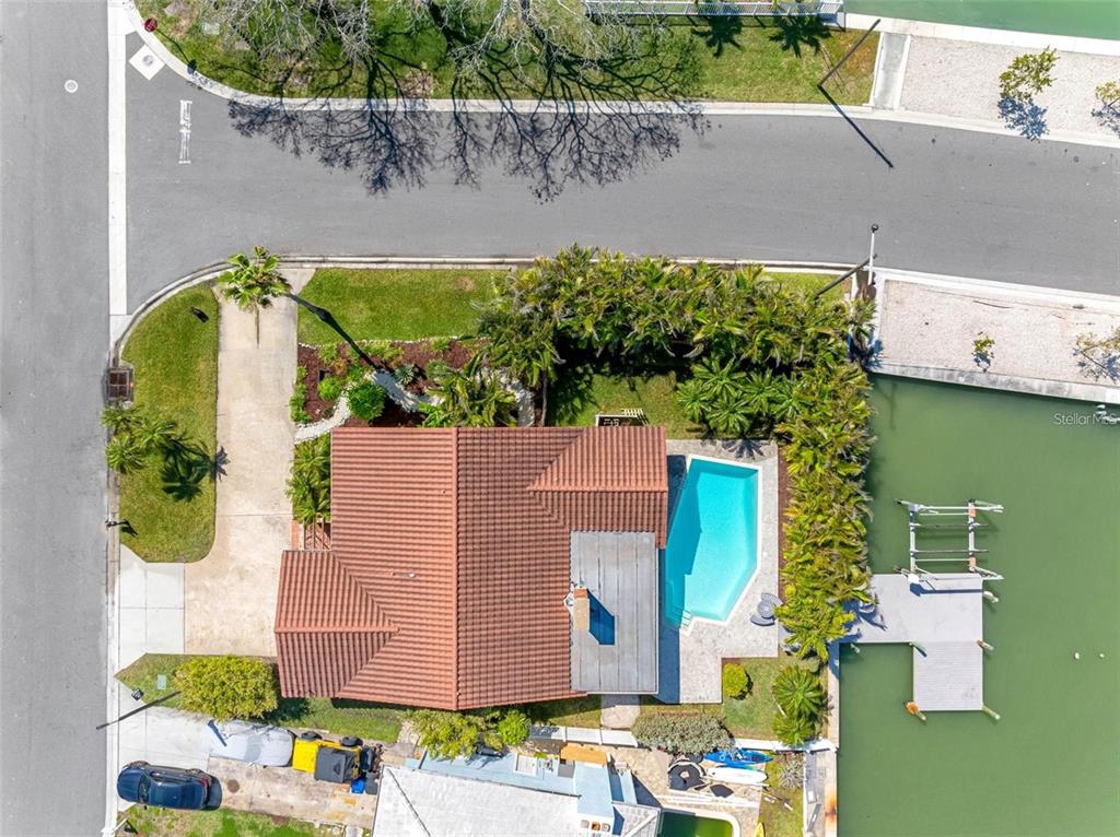 562 Johns Pass Avenue Madeira Beach, FL 33708 - Photo 1 of 51 an aerial view of a house with a garden and a car parked