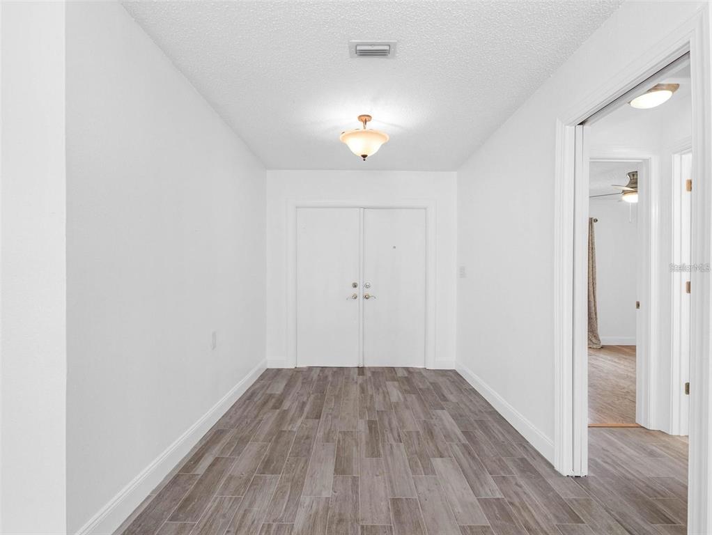562 Johns Pass Avenue Madeira Beach, FL 33708 - Photo 15 of 51 an empty room with wooden floor and windows