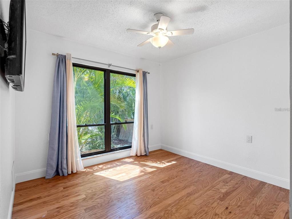 562 Johns Pass Avenue Madeira Beach, FL 33708 - Photo 22 of 51 en empty room with wooden floor and window