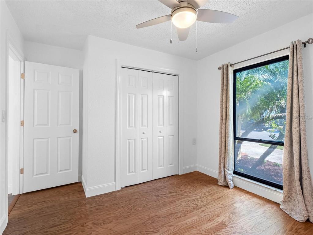 562 Johns Pass Avenue Madeira Beach, FL 33708 - Photo 23 of 51 an empty room with wooden floor and windows
