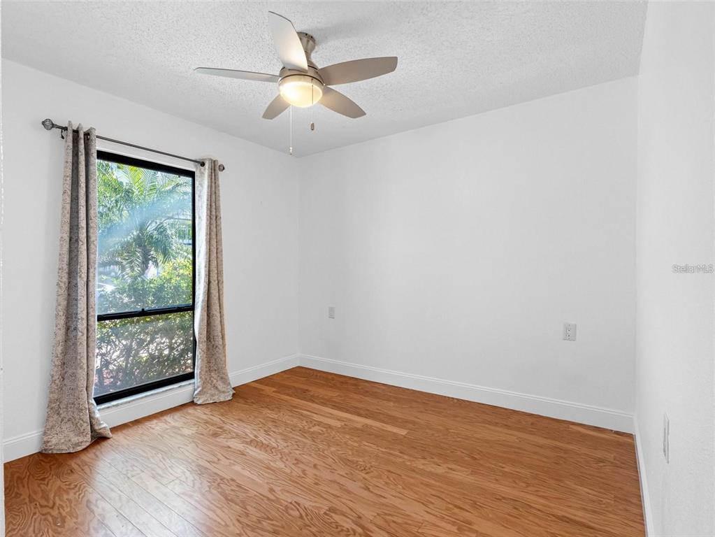562 Johns Pass Avenue Madeira Beach, FL 33708 - Photo 24 of 51 an empty room with wooden floor and windows