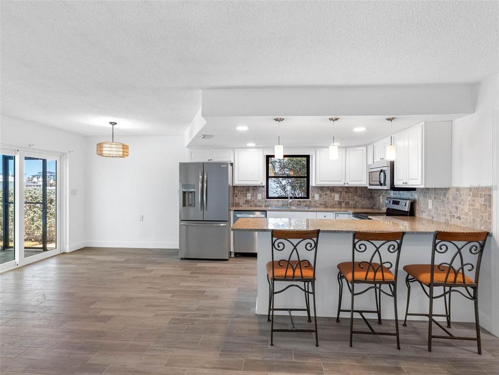 562 Johns Pass Avenue Madeira Beach, FL 33708 - Photo 26 of 51 a kitchen with stainless steel appliances a refrigerator and a stove top oven