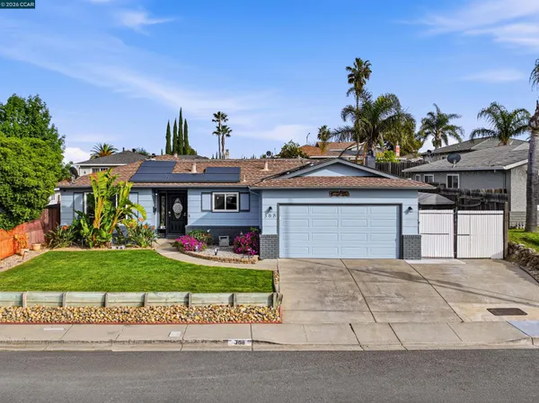 a front view of a house with a yard and potted plants