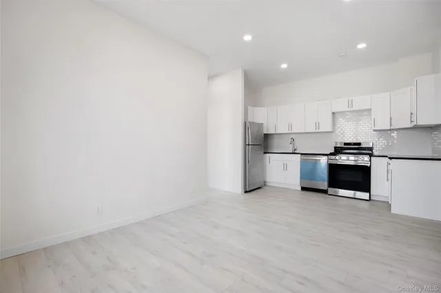 a kitchen with stainless steel appliances a refrigerator and a stove top oven