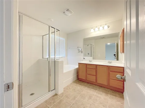 a spacious bathroom with a mirror a shower and vanity