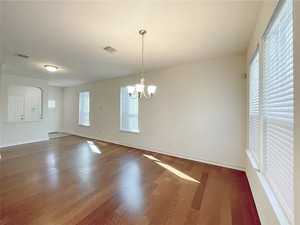 a view of a room with wooden floor and chandelier