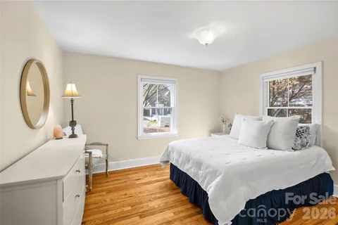 a bed room with a bed a mirror and a window