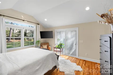 a bedroom with a large bed and a flat tv screen on dresser