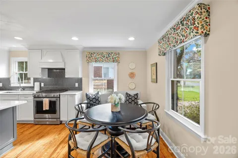 a kitchen with stainless steel appliances a table and chairs in it