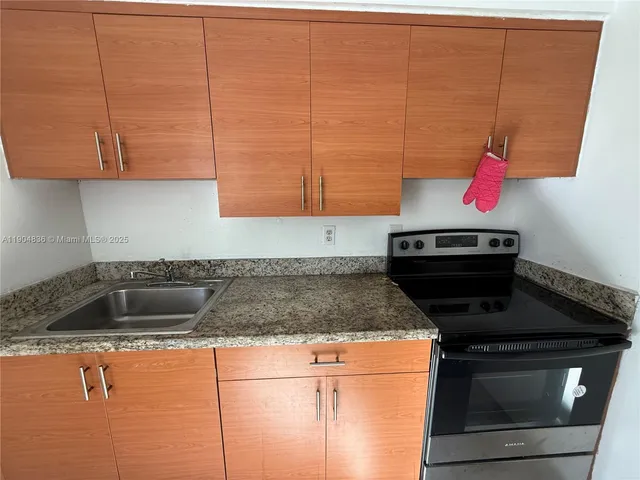 a kitchen with stainless steel appliances granite countertop a sink a stove and a microwave
